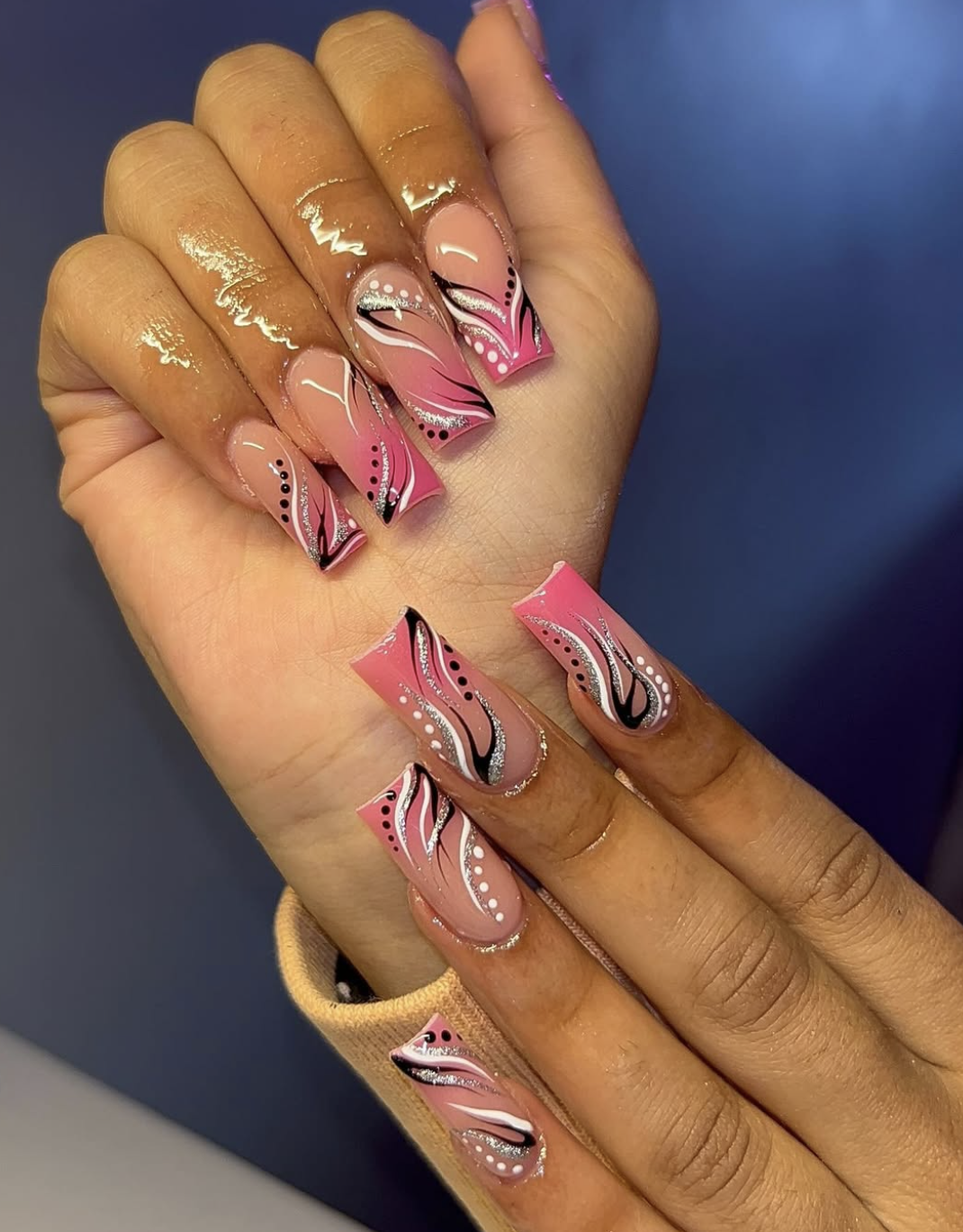 2026 nail trends: Modern Y2K nostalgia nails with pink and black graphic art and 3D detailing for a polished throwback look.