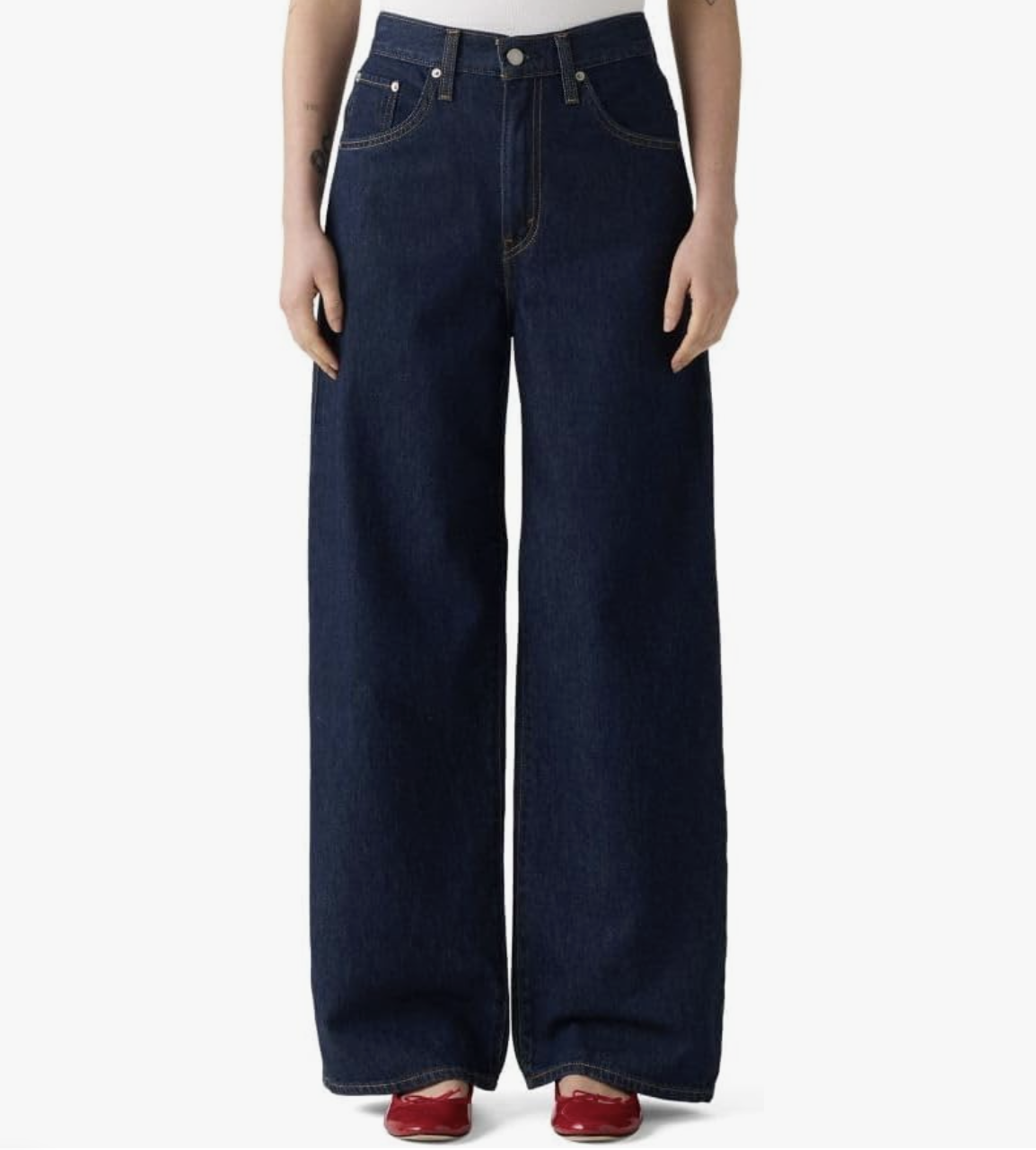 Pair of dark wash Levi's Cinch Baggy jeans with a wide-leg silhouette and extra-long hem, styled with red pointed-toe flats.
