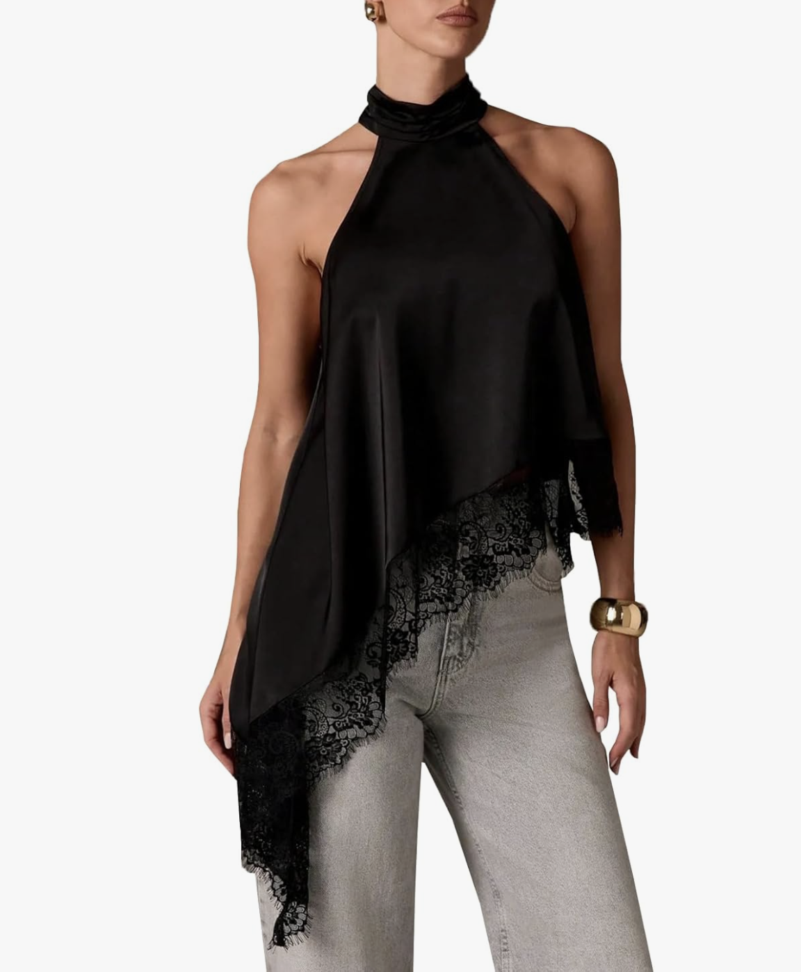A woman wearing a black satin asymmetrical halter top with a mock neck and delicate black lace trim at the hem, styled with light-wash jeans for a sophisticated date night look for women in their 50s.