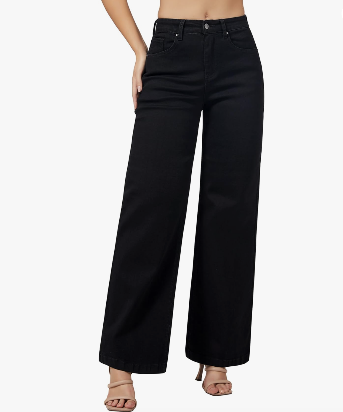 A close-up of a person wearing high-waisted, stretchy black wide-leg jeans paired with tan strappy heeled sandals.