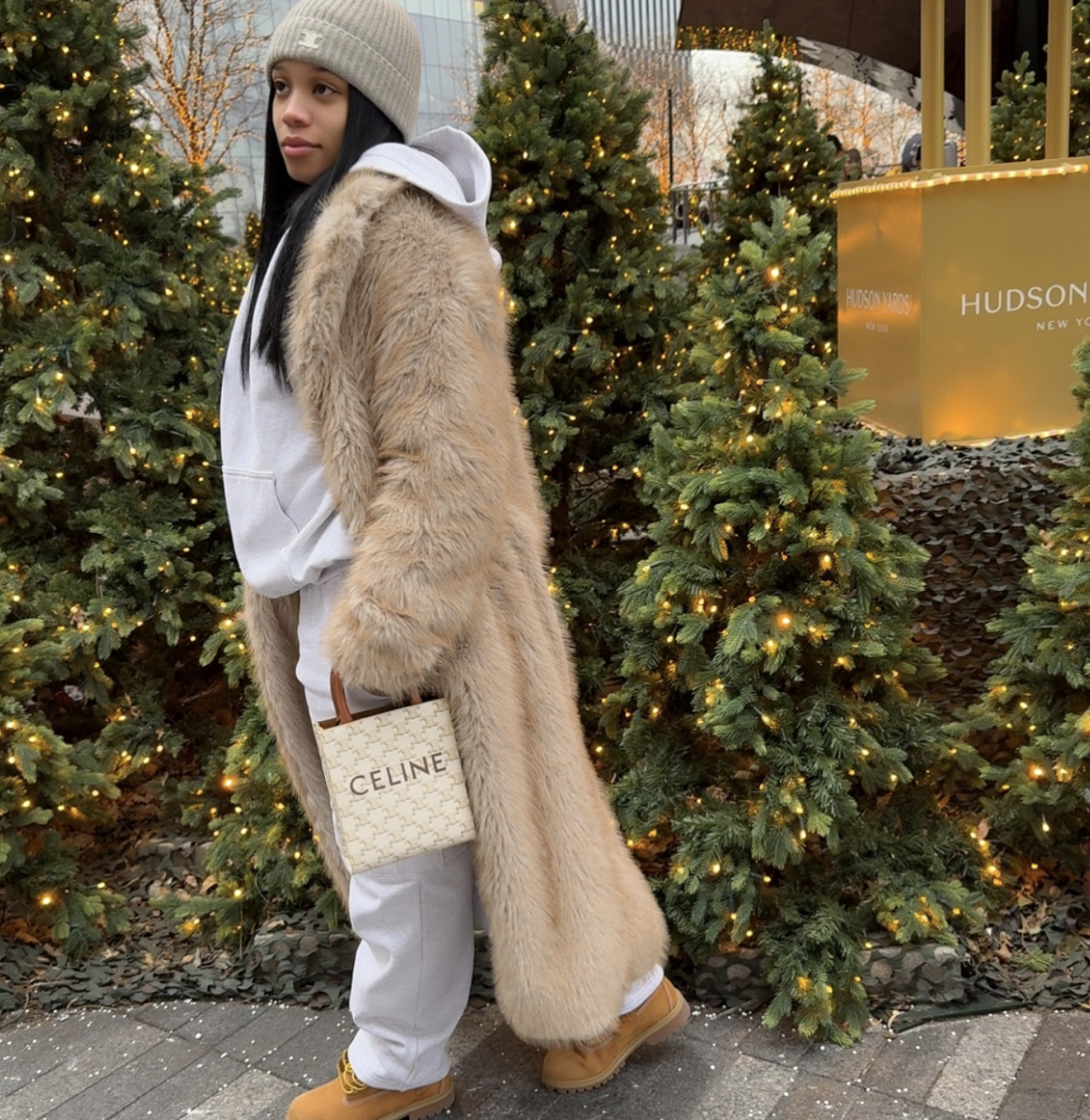 A white hoodie under a long beige coat.