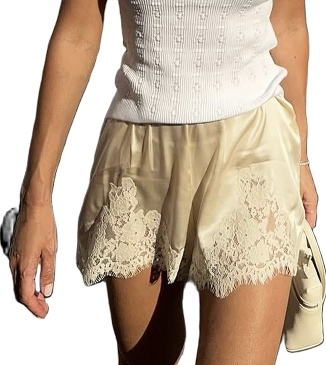 A close-up of a person wearing cream-colored satin micro shorts with delicate white floral lace trim, styled with a white ribbed tank top.