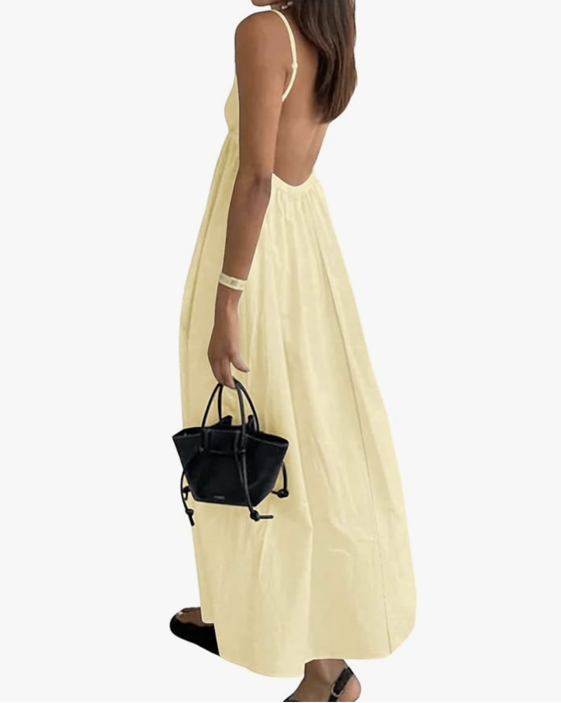 A back view of a vibrant yellow halter maxi dress with an open-back design, paired with a small black structured handbag.