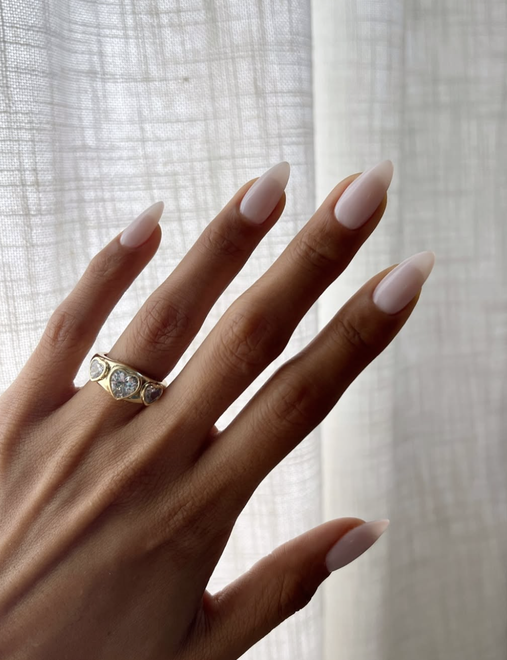 Sheer latte-colored nails with a glossy natural finish for fall 2026.