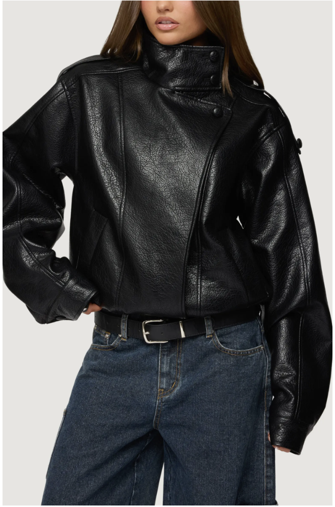 Black faux leather jacket with a high stand collar, front flap pockets, and a wide buckled waist belt, styled with dark denim jeans.