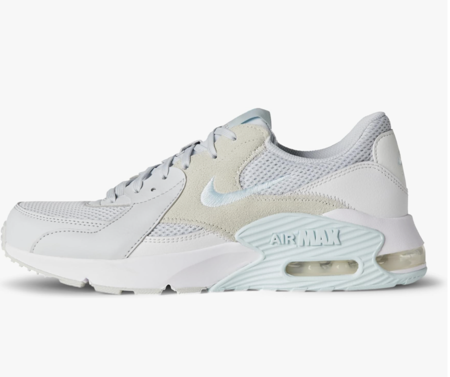 A pair of white and pure platinum Nike Air Max Excee sneakers with light blue accents, styled for a petite spring outfit.