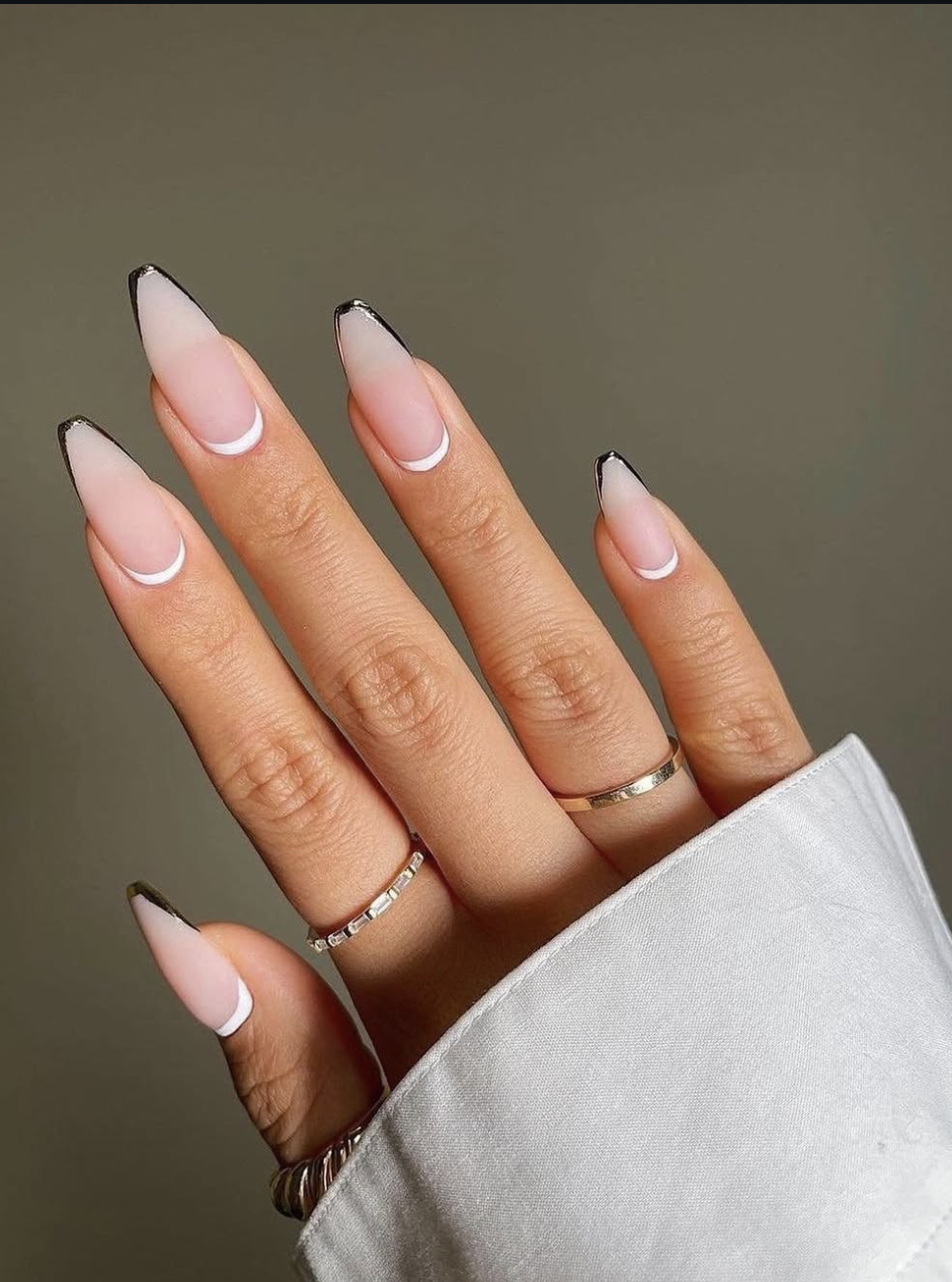 Long almond-shaped nails featuring a milky nude base and an ultra-thin, precise metallic silver micro French tip, highlighting cute June nail ideas.