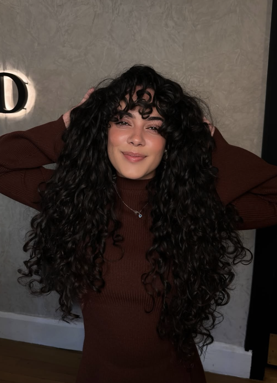Woman wearing long curtain bangs on wavy hair with soft face-framing movement