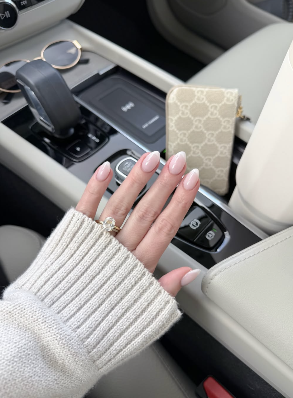 Long almond-shaped nails with a skin-tone nude base and a barely-there, thin beige French tip.