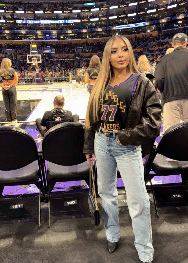 Woman wearing an oversized Chicago Sky jersey with long denim shorts, crew socks and sneakers.