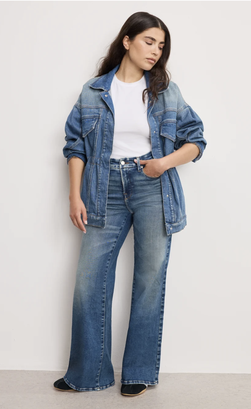 Woman wearing Good American Soft-Tech Good Waist palazzo jeans with a high rise and fluid wide leg.