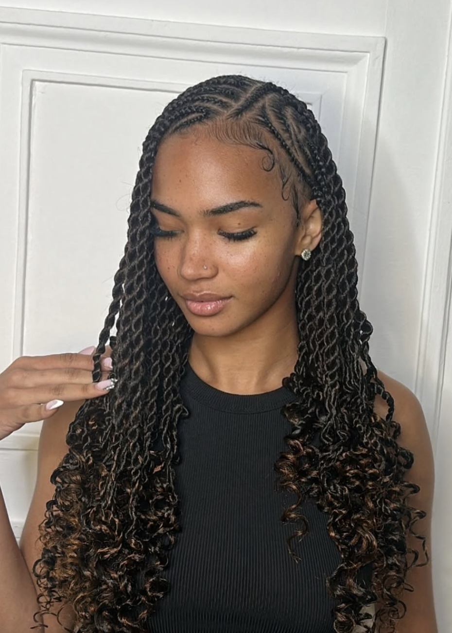 A close-up of a woman with neat flat twists along the scalp that transition into long, voluminous curly ends, featuring a clean side part and detailed edges.