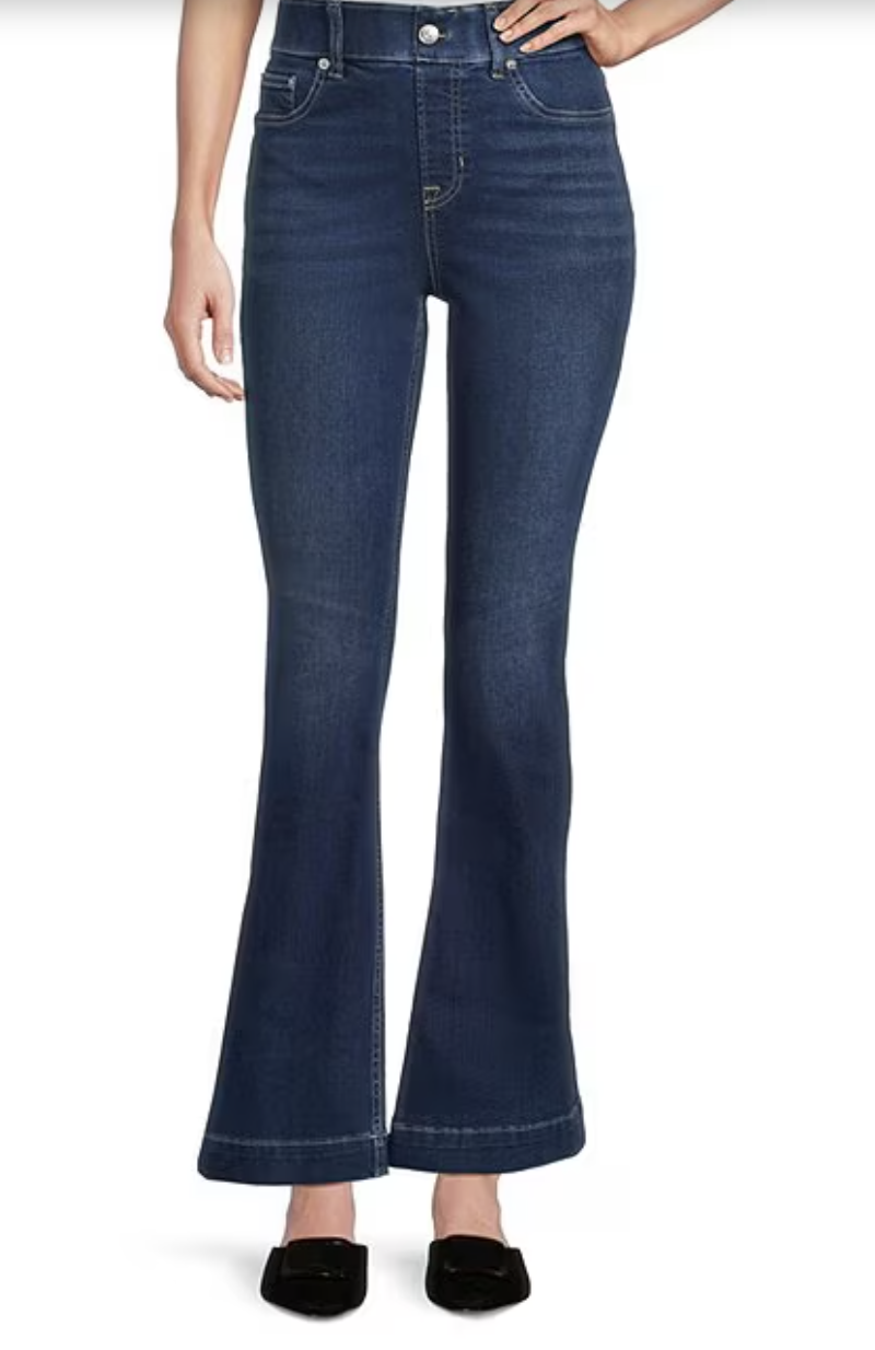 A pair of Spanx Everywear Zero Waistband Micro Flare Jeans in a dark indigo wash, featuring a pull-on design and a subtle flare at the hem, styled with black loafers.