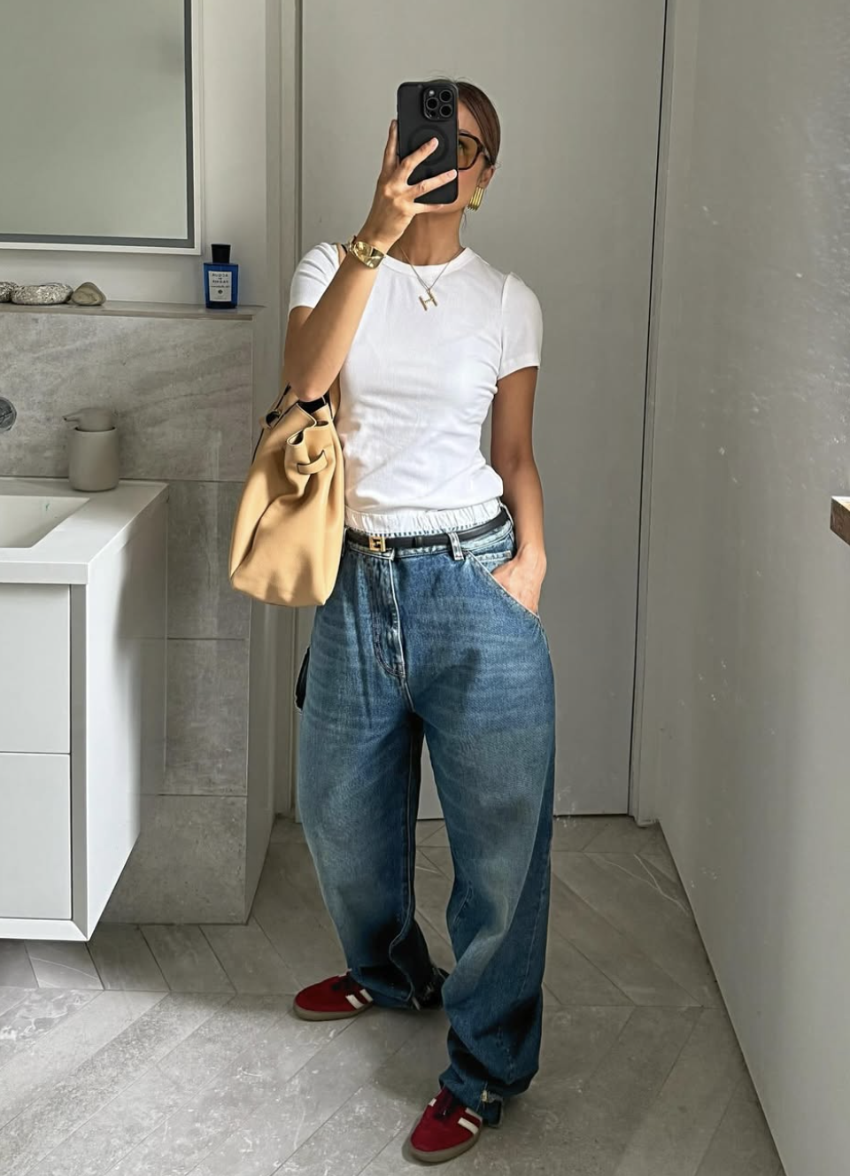 woman wearing a white t-shirt taking a mirror selfie
