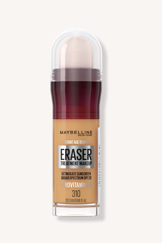 A close-up shot of the Maybelline Instant Age Rewind Eraser Treatment Makeup foundation bottle in shade 310, showing the built-in micro-corrector sponge applicator.