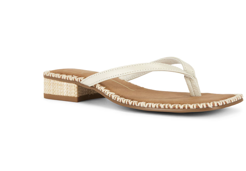 Side view of a white leather flat thong sandal featuring a beige woven raffia block heel against a transparent background.