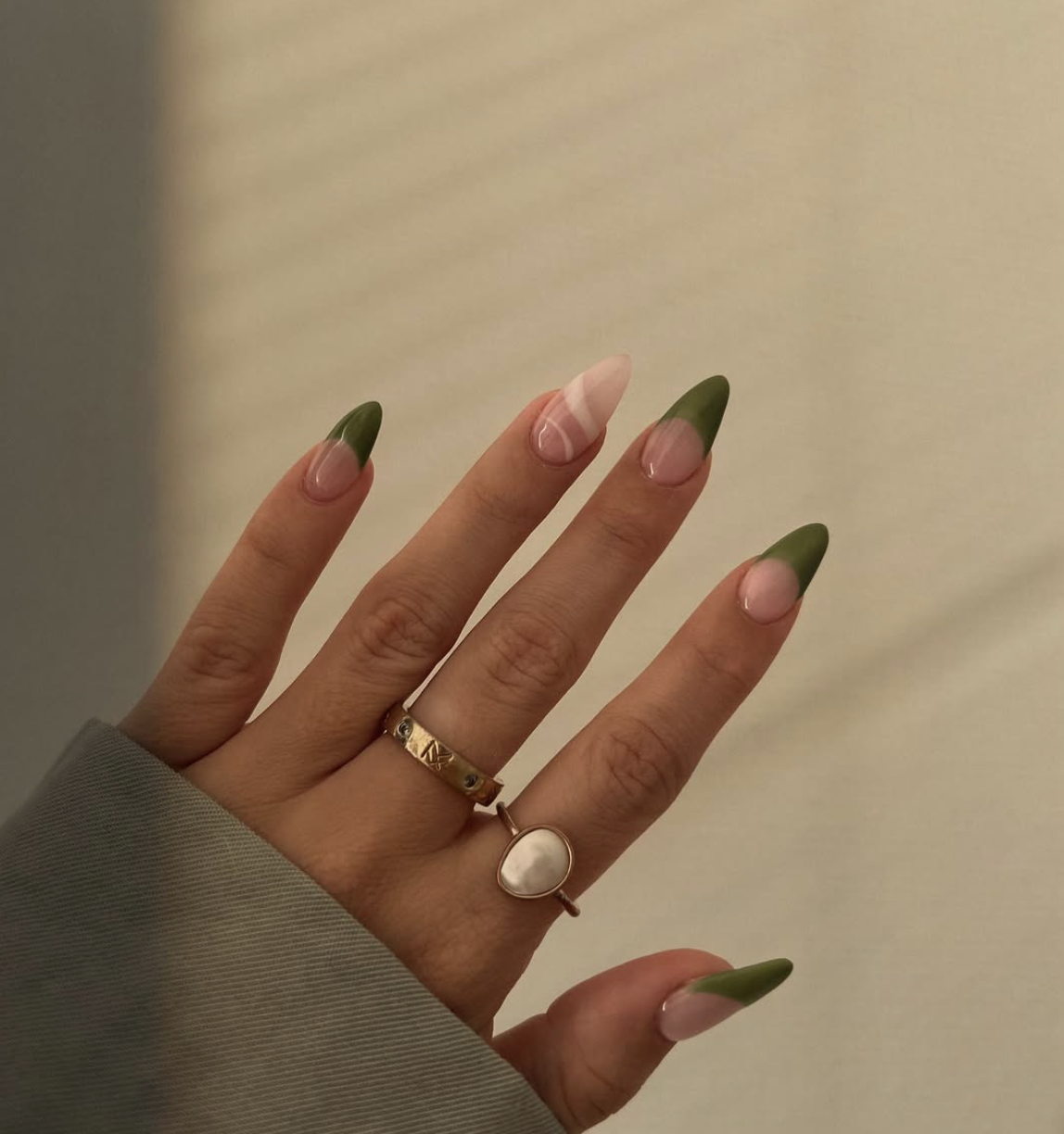 Almond shaped nails with a creamy matcha green French tip design and a high-gloss finish.