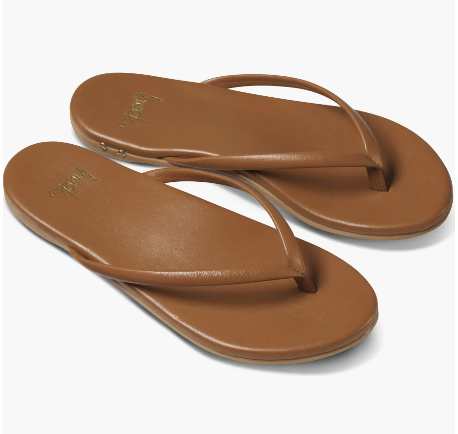 A pair of tan leather Beek Sunbeam flip-flops with a thin strap and gold stud detailing on a clean white background.