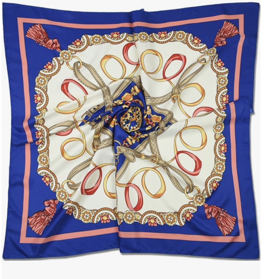 A large square silk scarf with a deep blue border and a cream center featuring a nautical rope and tassel pattern, laid out flat to show the design before being used as a belt.