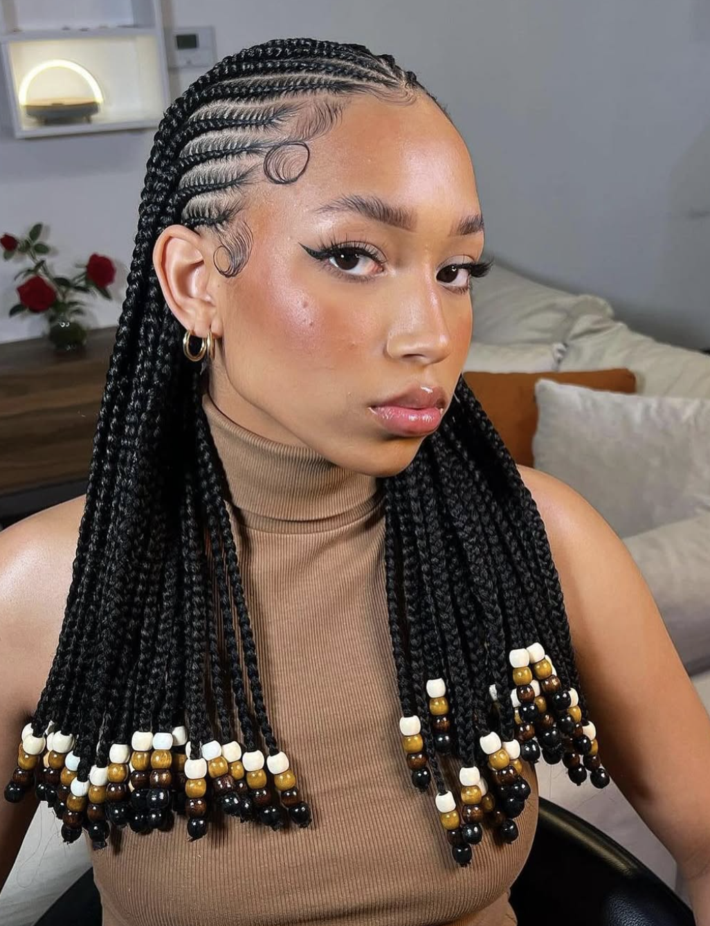 Shoulder-length individual braids finished with decorative beads at the ends.