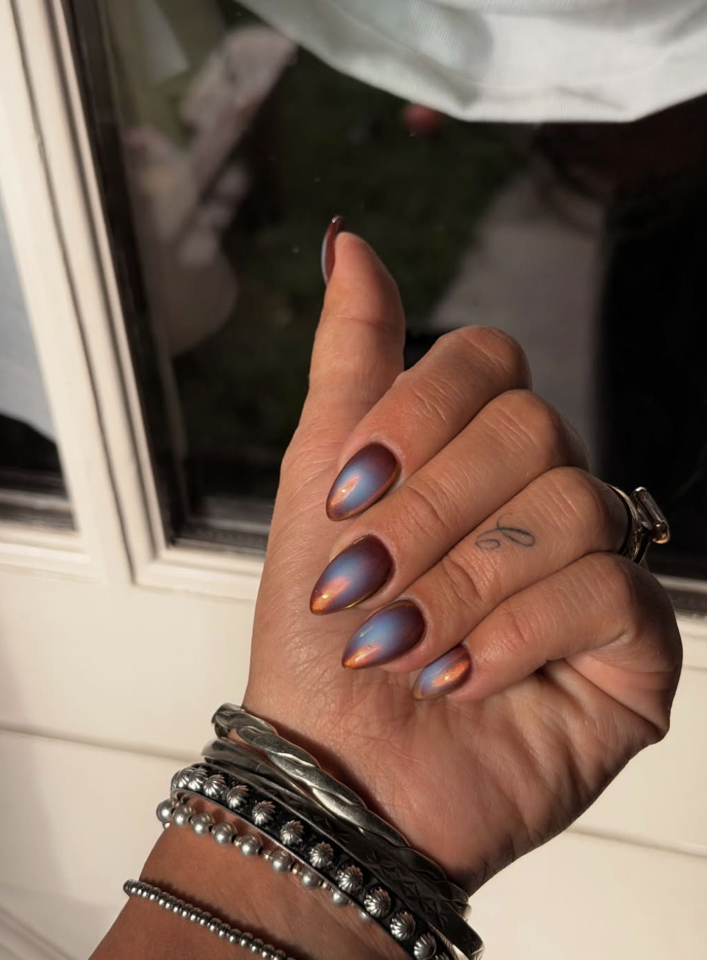 Burgundy magnetic velvet aura nails with a glossy finish.
