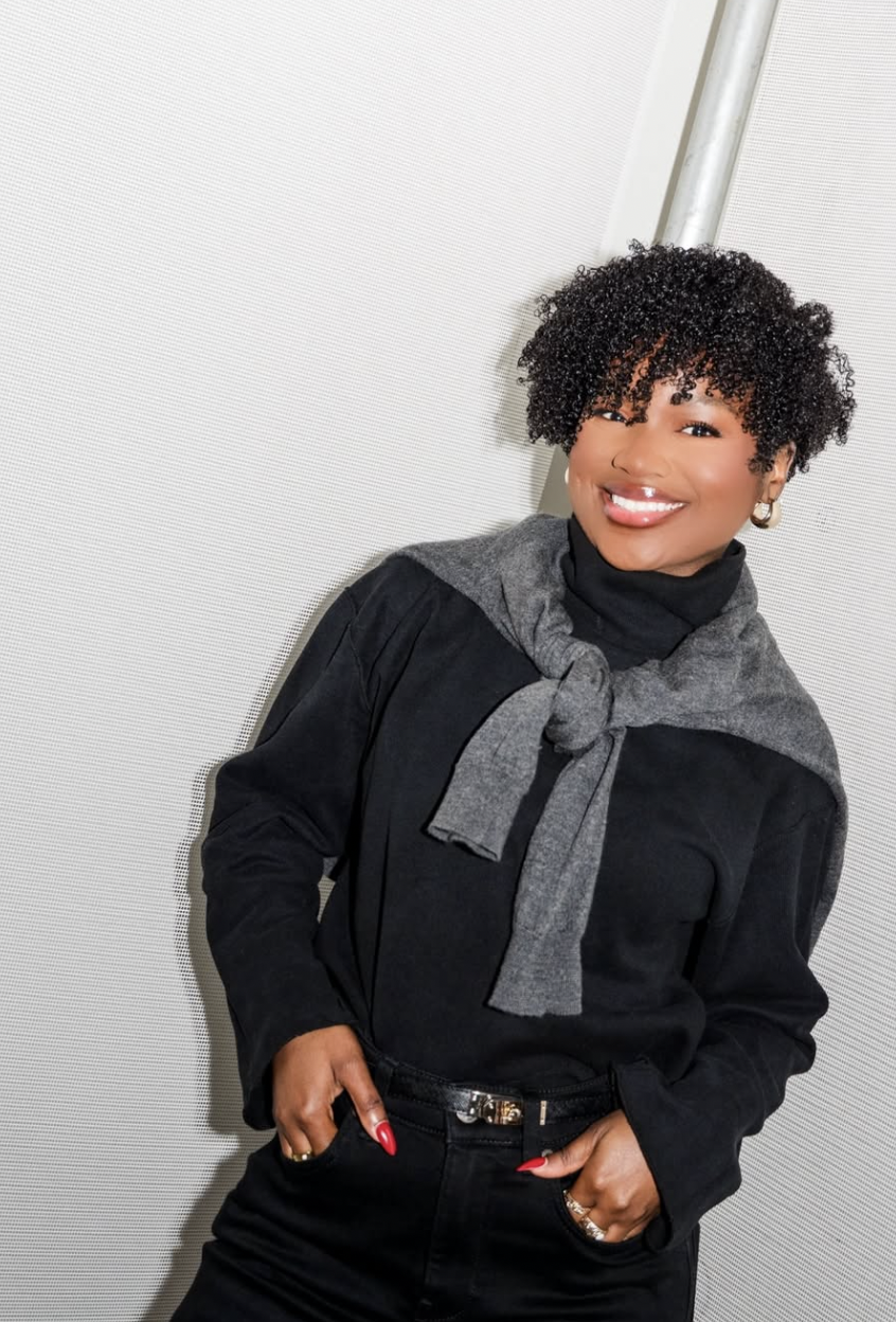 Denny Daily showcasing a Teeny Weeny Afro (TWA) with defined natural curls and tapered sides, highlighting sharp cheekbones and an angular diamond face shape.