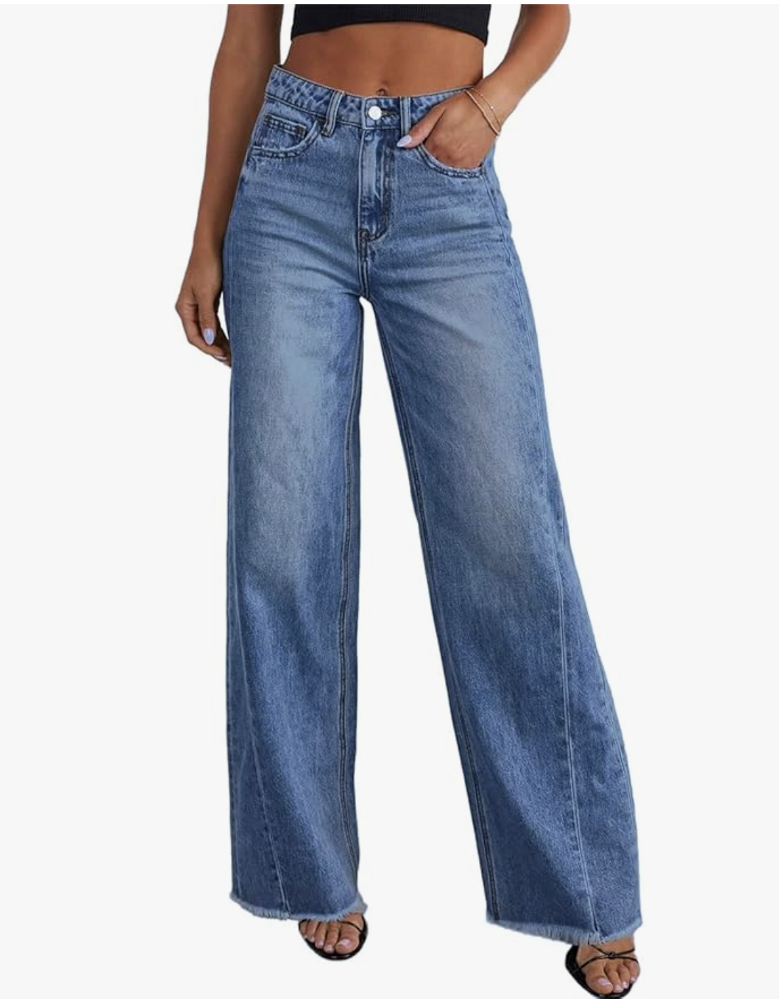 A close-up view of a woman wearing light-wash, high-waisted wide-leg jeans from Amazon, styled with a cropped black top and sandals.