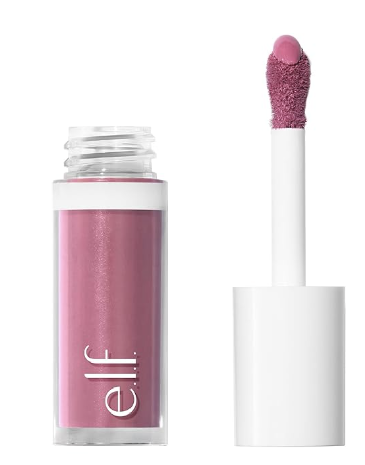 A close-up product shot of the e.l.f. Camo Liquid Blush bottle in a dusty pink shade, highlighting its clean cylindrical packaging and white cap with the rounded doe-foot applicator wand resting beside it.