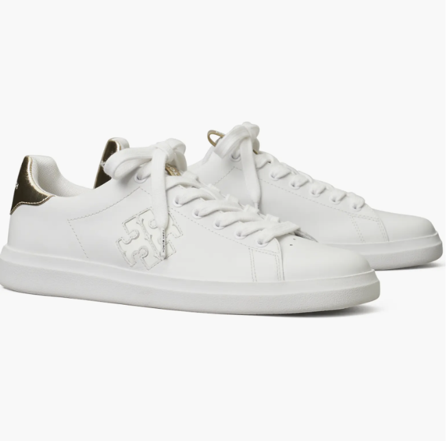 pair of white leather Tory Burch Howell Court Sneakers with a gold logo on the side and a gold metallic heel tab.