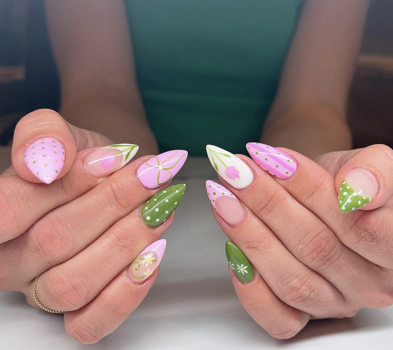 A high-feminine spring manicure by @az.naildesigns featuring almond-shaped nails with hand-painted pink tulips, strawberries, and green polka dots on a soft pink and white base.