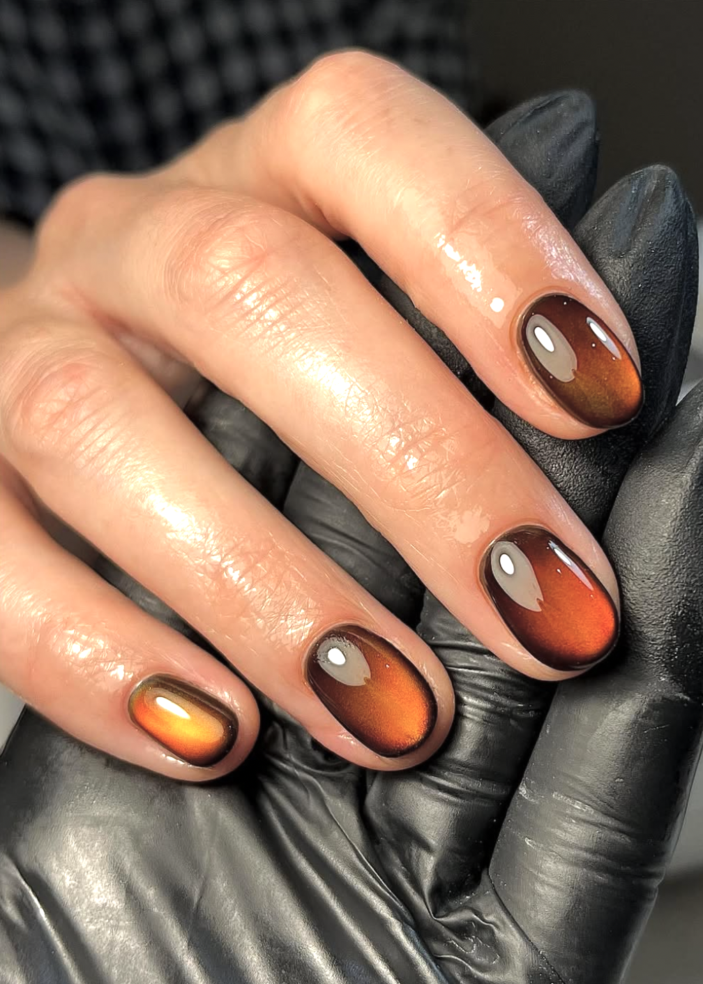Almond nails with glowing amber centers fading into espresso-brown edges.