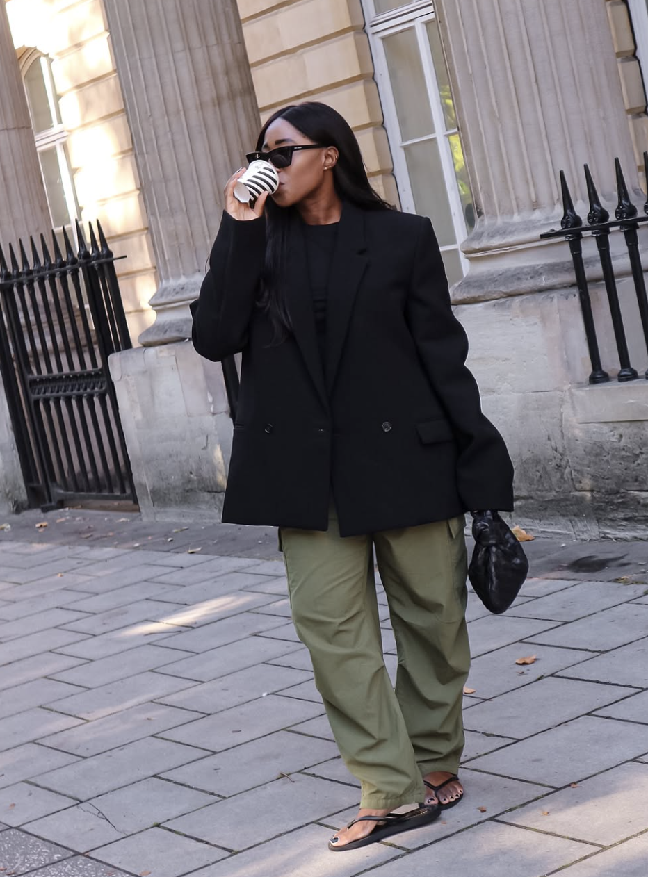 Styling dark green pants with a black knit top and matching black accessories for a high-contrast look.