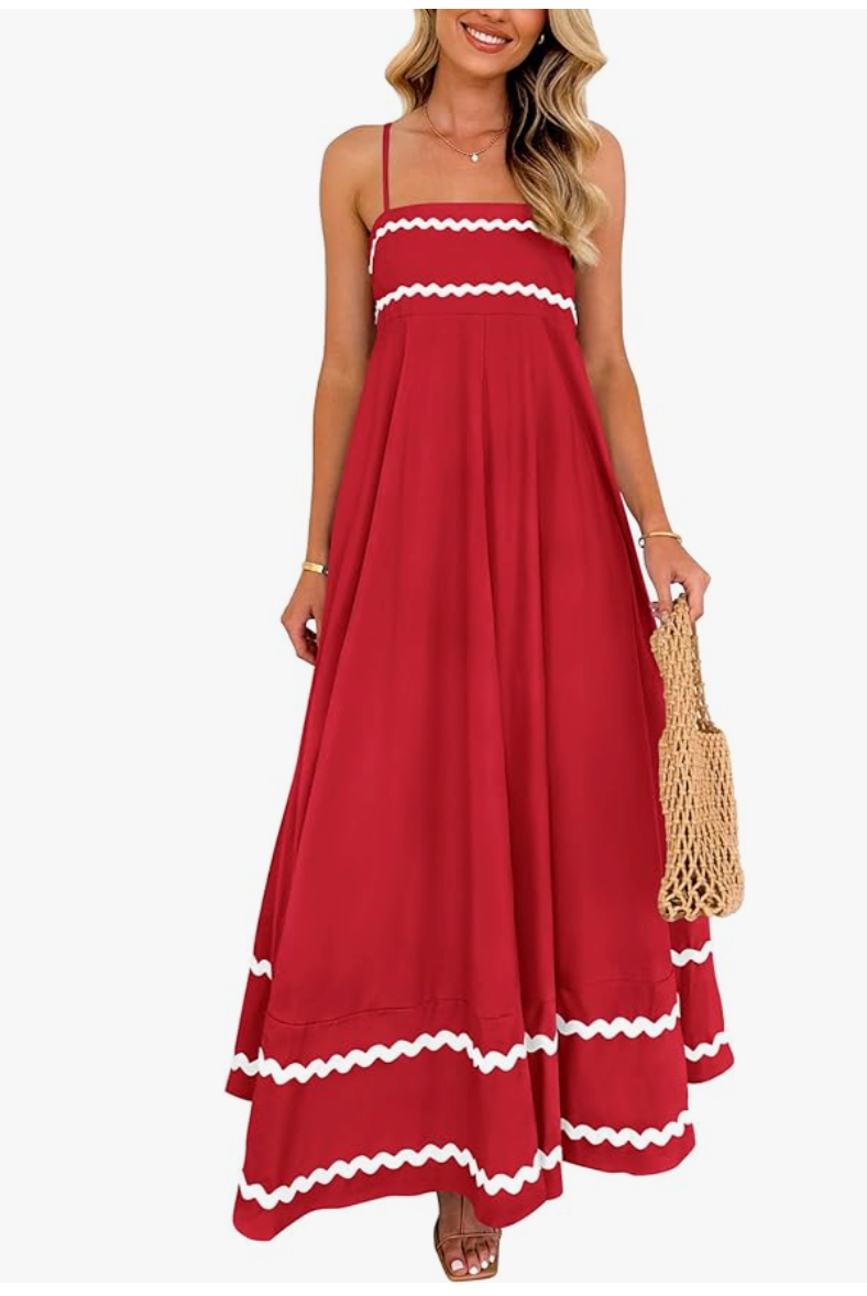 Fashion editor wearing a tiered red flowy maxi dress with white rick-rack trim and spaghetti straps, demonstrating a breezy 2026 summer outfit formula.