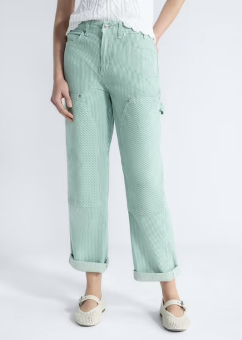 A close-up view of a woman wearing high-waisted mint green corduroy utility pants featuring carpenter-style paneling and a side hammer loop detail.