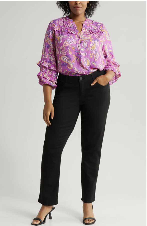 Dark-wash straight-leg jeans styled with a camel cardigan and supportive loafers for women over 60.