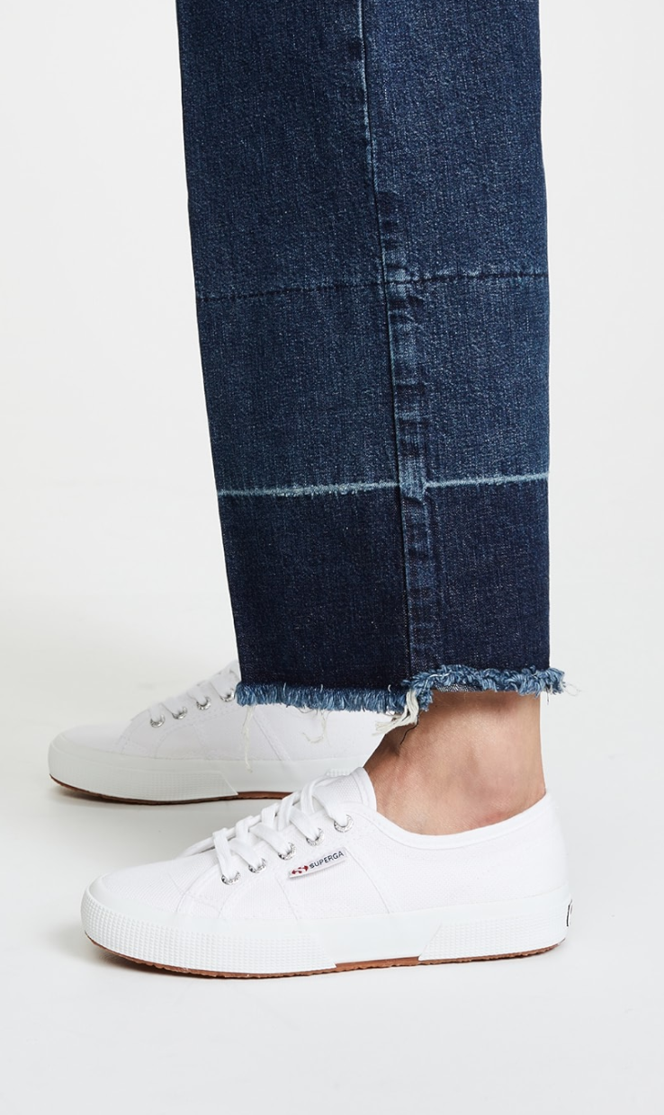Side view of Superga 2750 Cotu Classic Sneakers in white canvas with a natural gum rubber sole, styled with frayed hem straight-leg jeans.