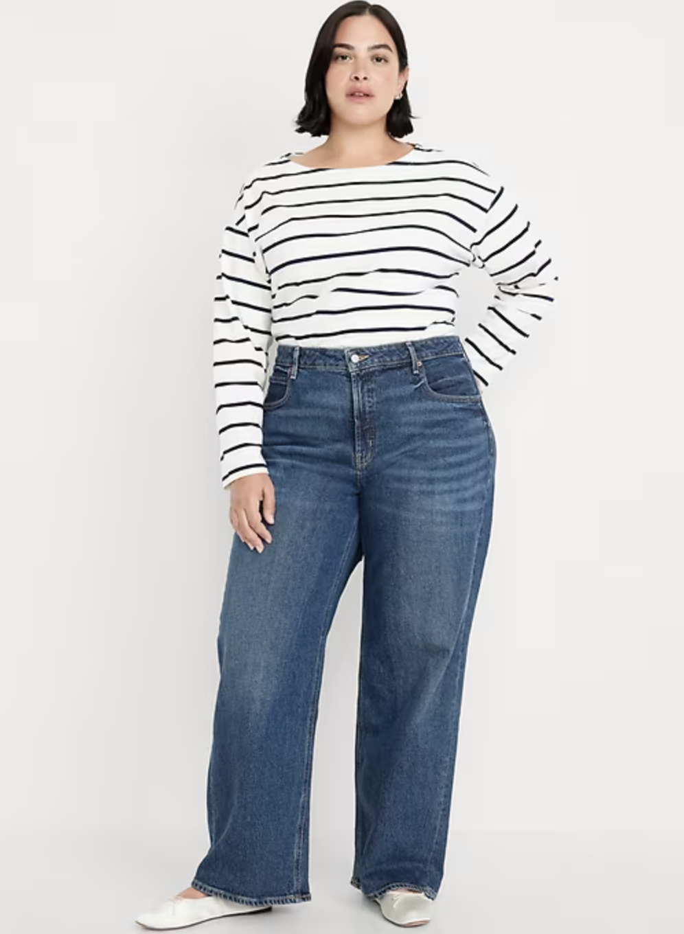 A woman wearing dark wash Old Navy Extra High-Waisted Wide-Leg Jeans in a petite fit, styled with black loafers for a classic look.