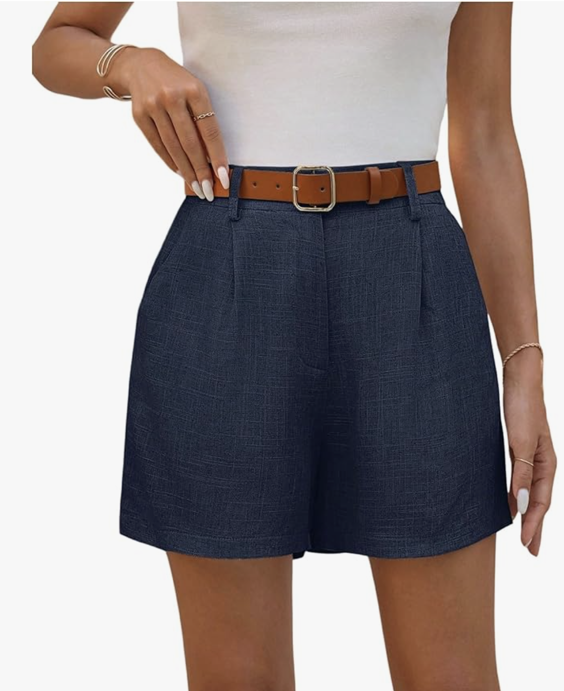 A pair of navy blue linen shorts with a brown leather belt, styled as a summer outfit idea to wear with flats for women.