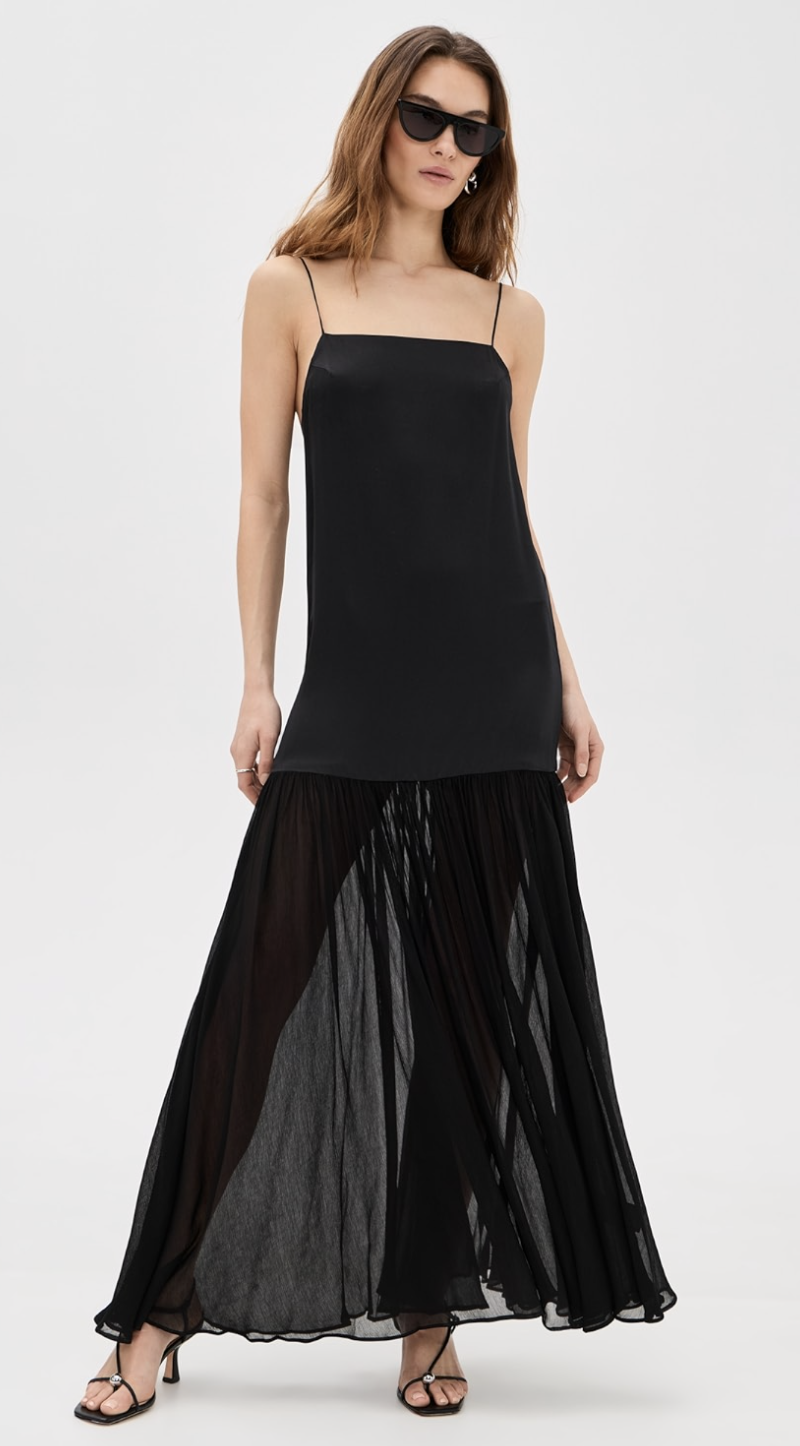 A woman wearing the Anine Bing Clementine Dress, a black satin midi-length slip dress with thin spaghetti straps and a subtle flared hem.