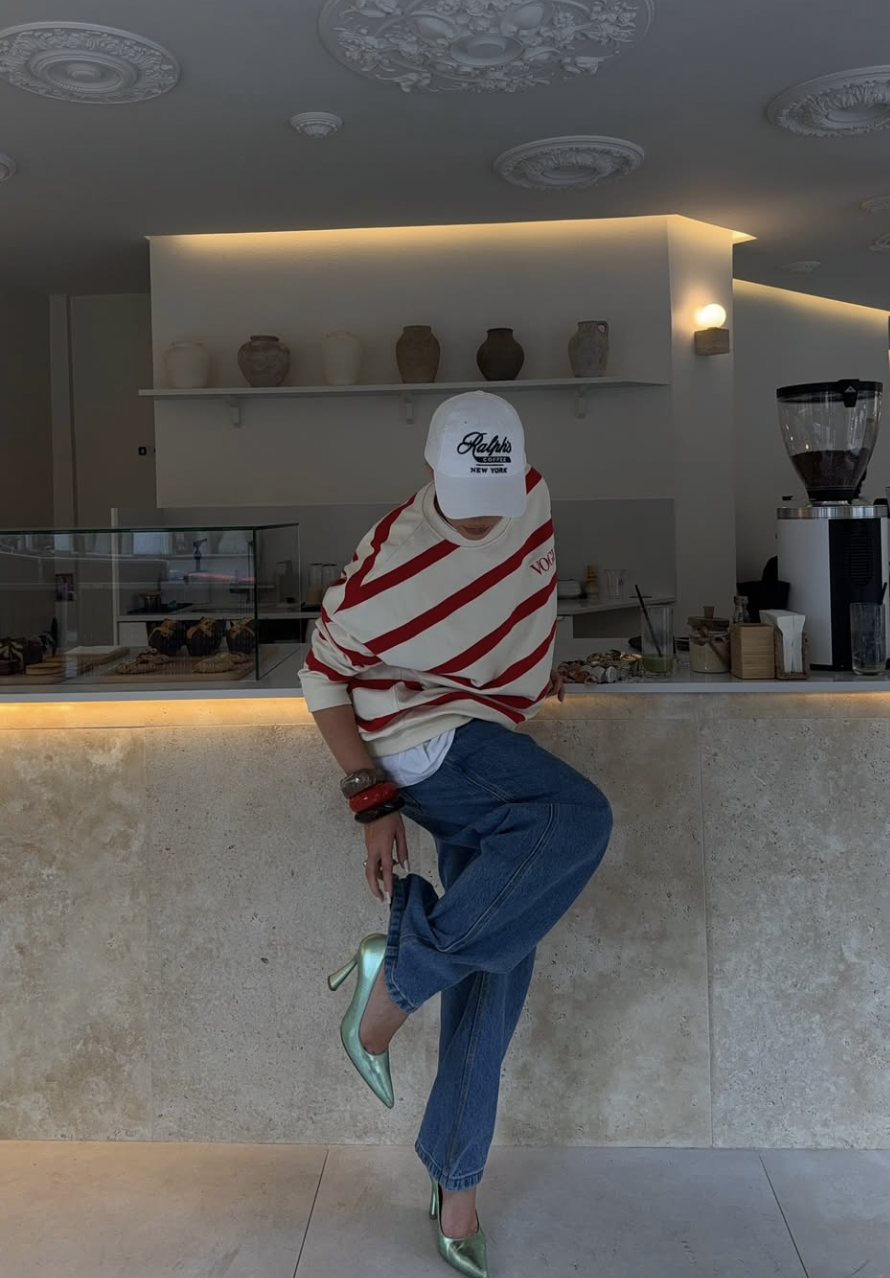 A street style lookbook image of a woman wearing a white t-shirt tucked into cuffed straight-leg jeans, paired with pointed-toe mint green heels. This illustrates a high-low outfit formula that balances casual basics with elevated footwear.