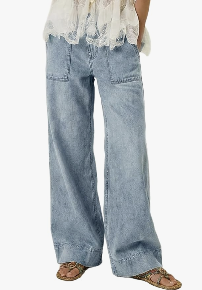 A woman wearing light-wash, high-waisted wide-leg jeans with distressed hems, styled as part of a casual blazer outfit formula.