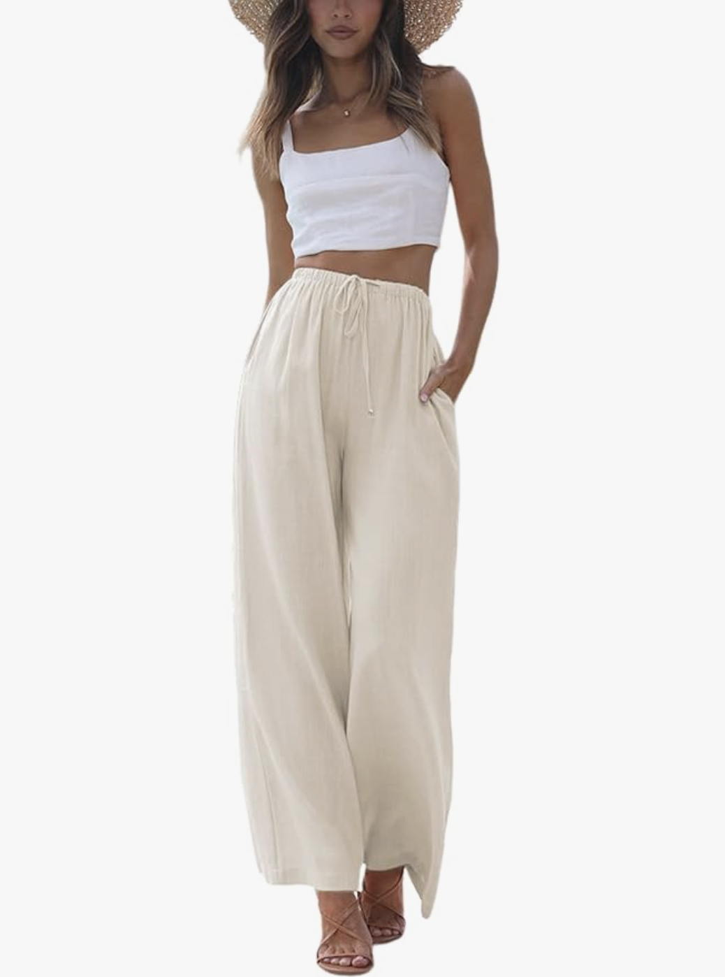 A woman wearing beige Cotton Linen Summer Palazzo Pants with a high-waisted drawstring and wide-leg silhouette, paired with a white crop top and straw hat for a summer BBQ.