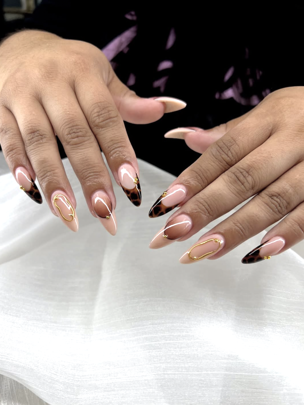 Close-up of tortoiseshell french tips on neatly manicured hands