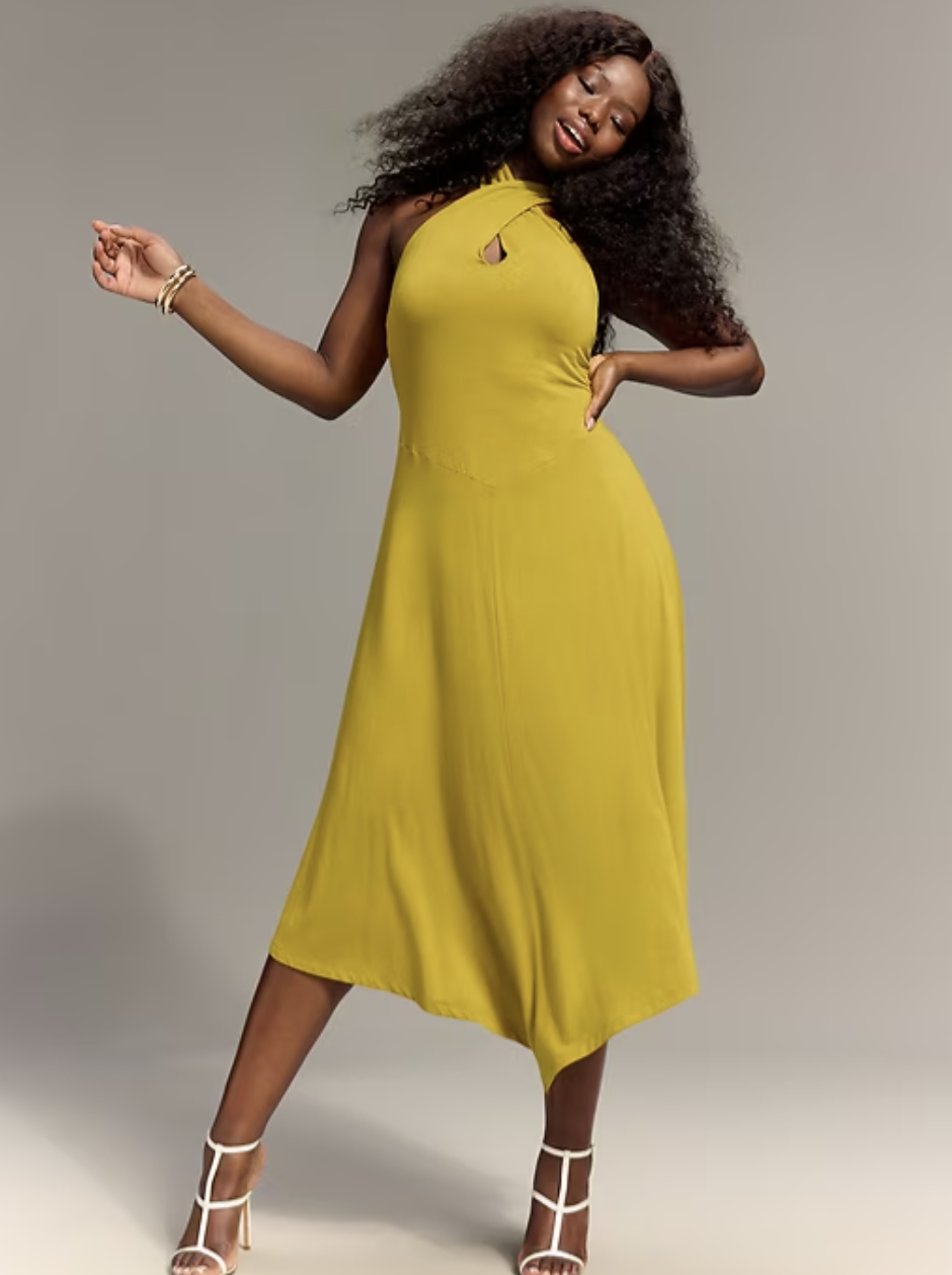 Model wearing the Old Navy x Christopher John Rogers chartreuse yellow drop-waist halter maxi dress with white strappy heels.