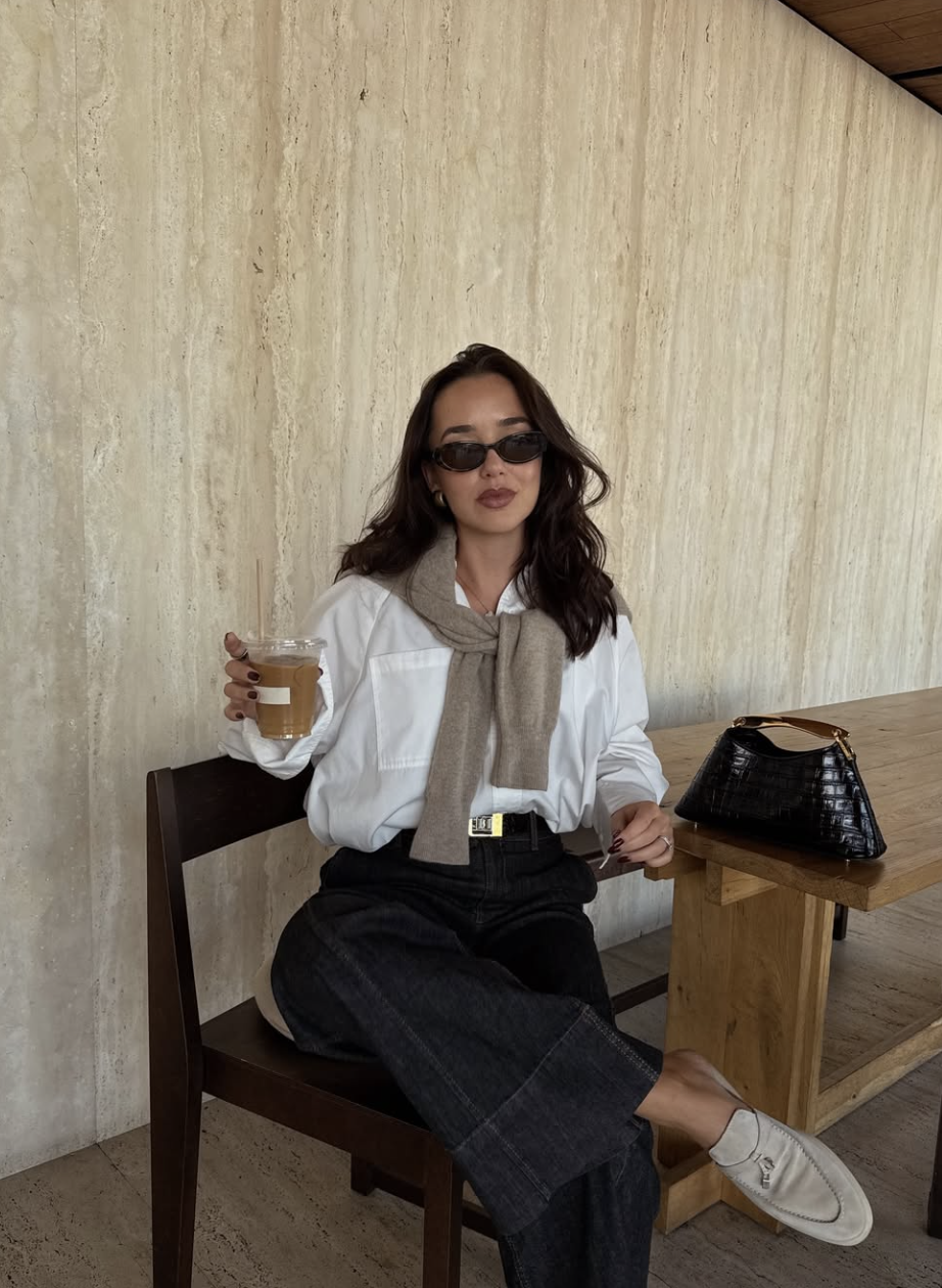 A fashion editor-inspired outfit featuring a white t-shirt paired with dark-wash skinny jeans and a neutral cardigan, demonstrating a modern take on classic skinny denim for 2026.