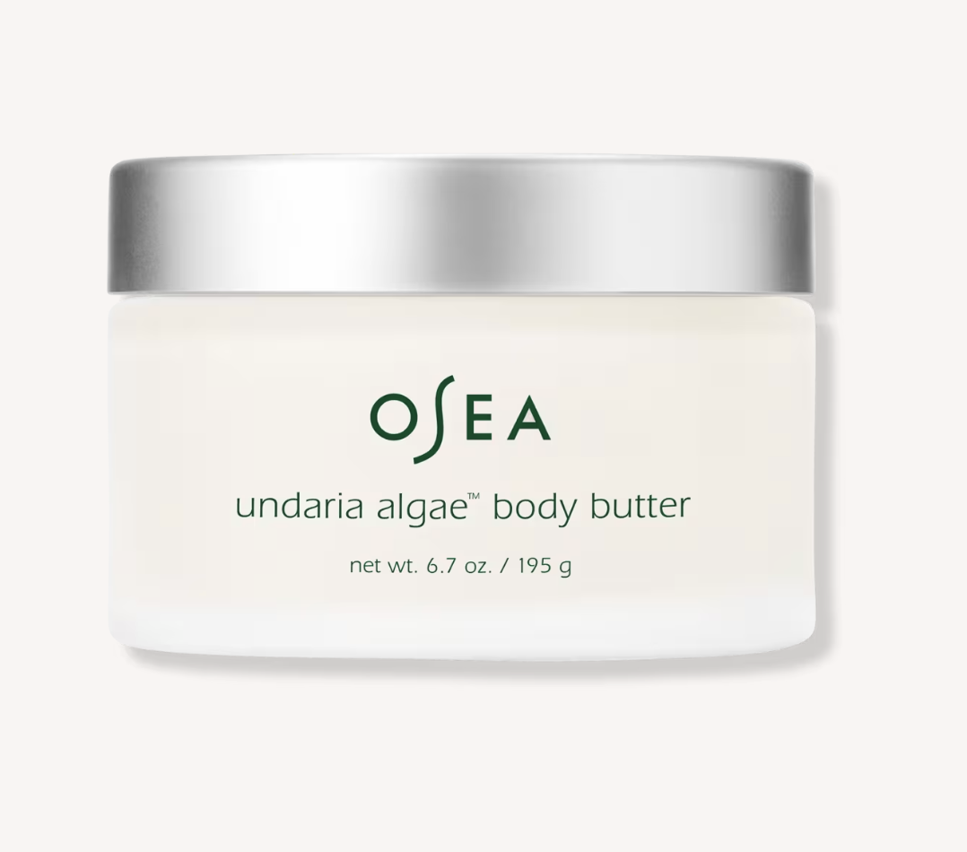 OSEA Undaria Algae Body Butter jar beside a folded cream towel.