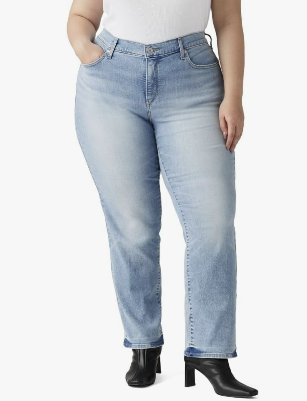 A person wearing light-wash Levi’s 314 Shaping Straight Jeans with a supportive mid-rise waistband, styled with black square-toe heeled boots.