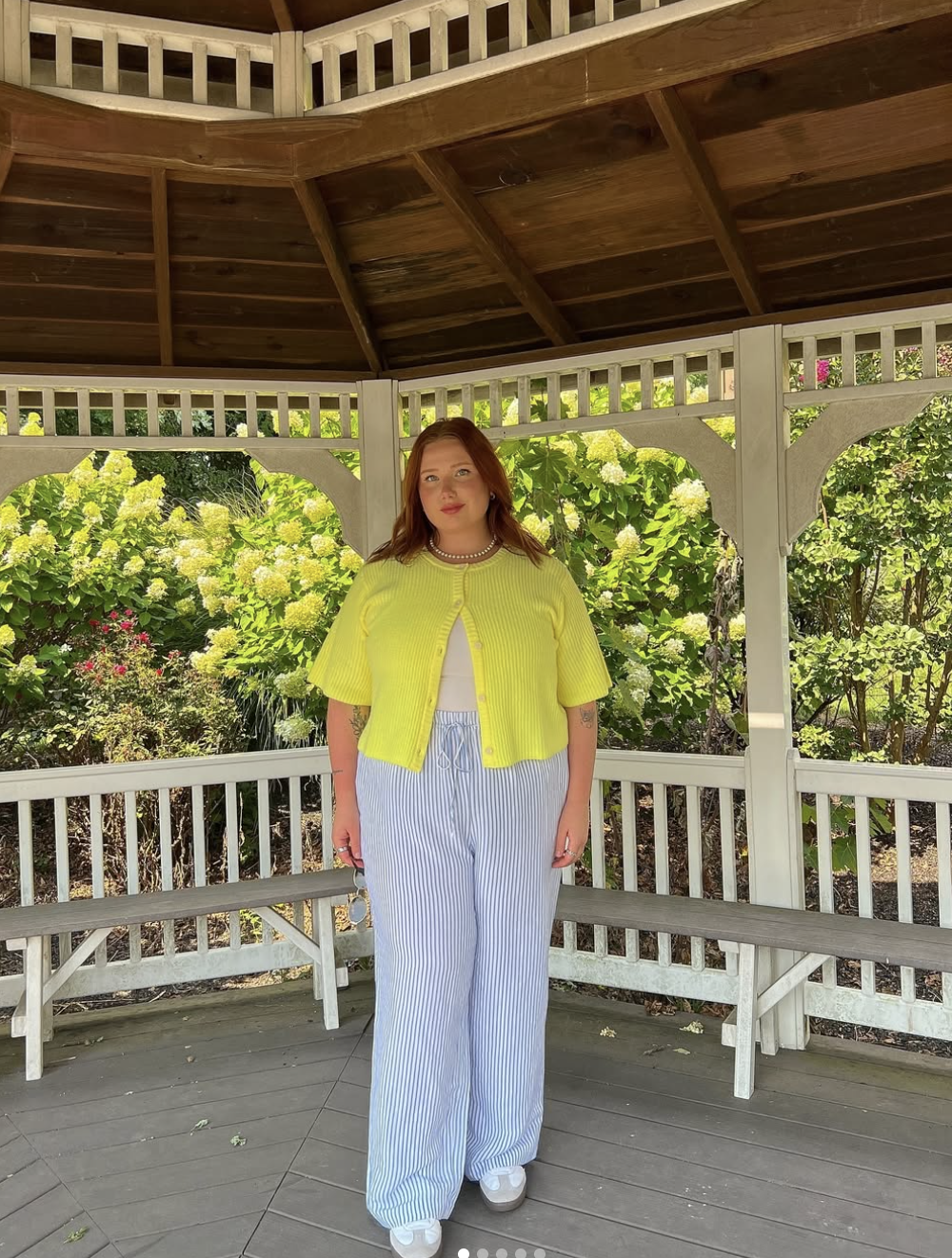 Plus-size woman wearing high-waisted blue and white striped wide-leg pants paired with a bright yellow ribbed short-sleeve cardigan.