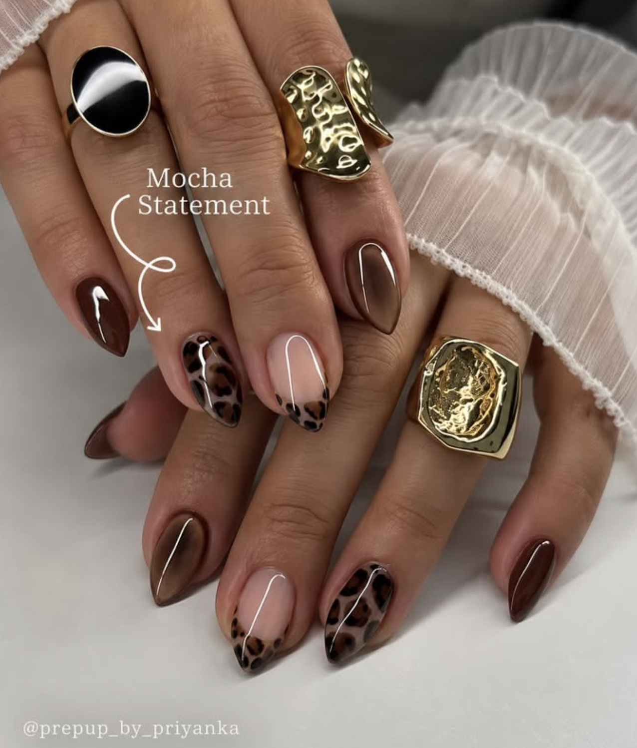 caramel nude nails with tiny tortoiseshell accents manicure photographed close up on hands.