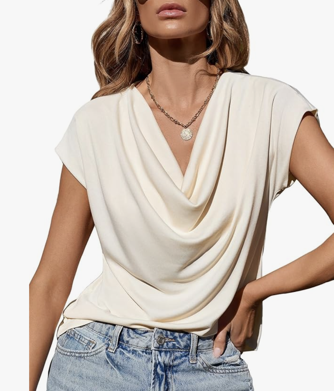 Product shot of a white sleeveless cowl neck top with a draped neckline, featured as a dressy option to add movement and shine to a baggy jeans outfit.